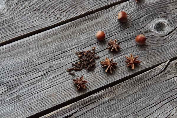 Wood nut, cinnamon sticks, a carnation and anise asterisks on a — Stock Photo, Image