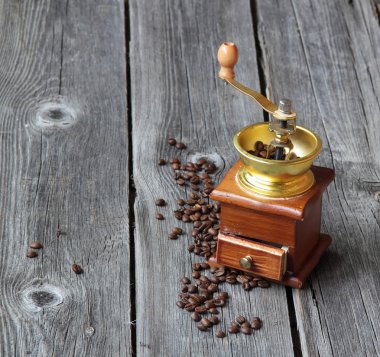 Kahve taneleri ve ahşap bir masa üzerinde el ile değirmen