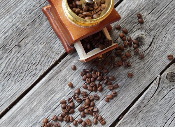 Granos de café y molino manual sobre una mesa de madera — Foto de Stock