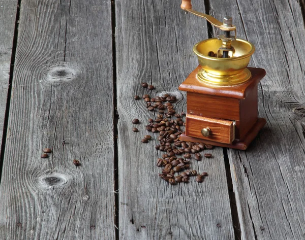 Grãos de café e moinho manual em uma mesa de madeira — Fotografia de Stock