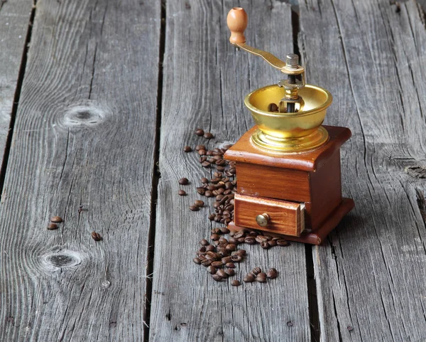 Grãos de café e moinho manual em uma mesa de madeira — Fotografia de Stock