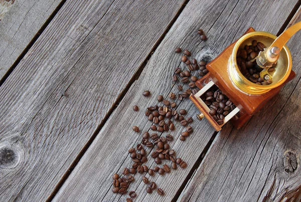 Grãos de café e moinho manual em uma mesa de madeira — Fotografia de Stock