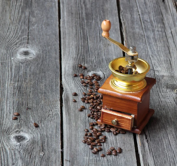 Coffee grains and manual mill on a wooden table — Stock Photo, Image