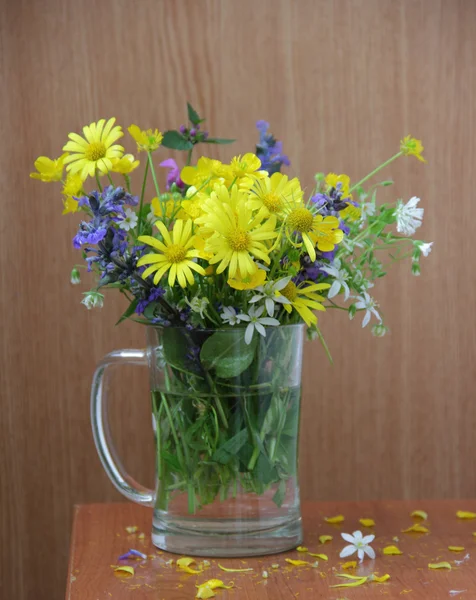 Strauß Frühlingswildblumen in einem durchsichtigen Becher — Stockfoto