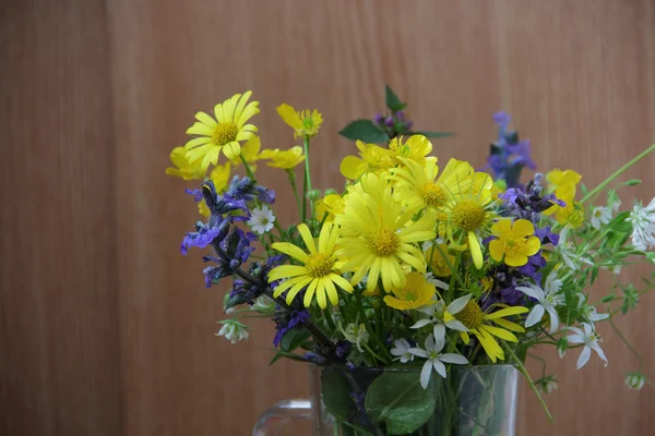 Strauß Frühlingswildblumen in einem durchsichtigen Becher — Stockfoto