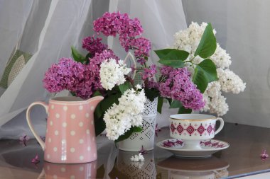 Ajur vazo ve bir fincan çay ile Lila buket