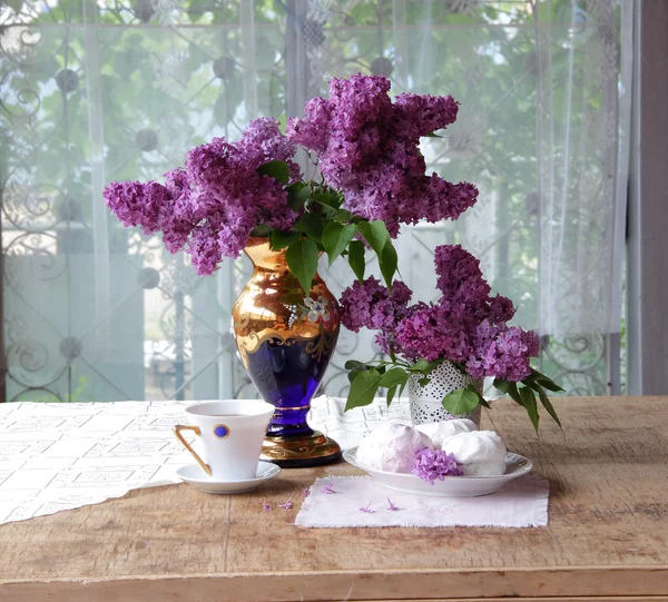 Bodegón con un zephyr, una taza de té y un ramo de lila — Foto de Stock