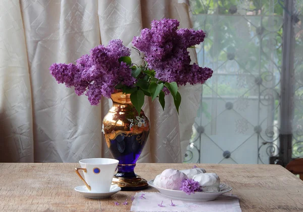 Bodegón con un zephyr, una taza de té y un ramo de lila — Foto de Stock