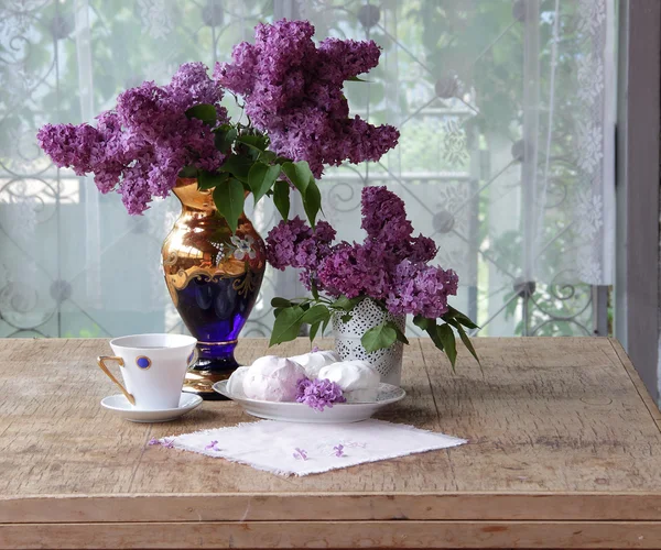 Bodegón con un zephyr, una taza de té y un ramo de lila — Foto de Stock