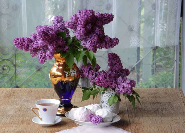 ゼファー、紅茶のカップとライラックの花束のある静物 — ストック写真