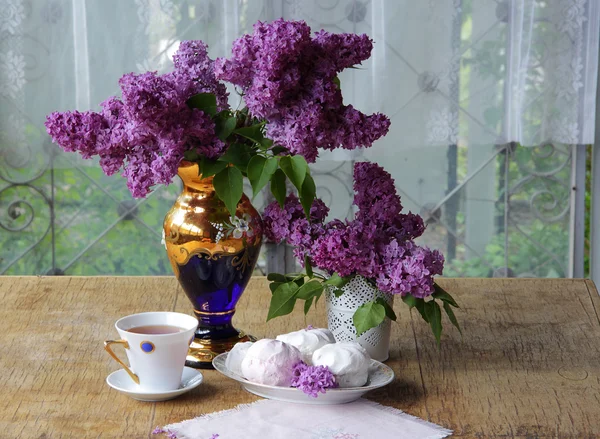 Bodegón con un zephyr, una taza de té y un ramo de lila — Foto de Stock