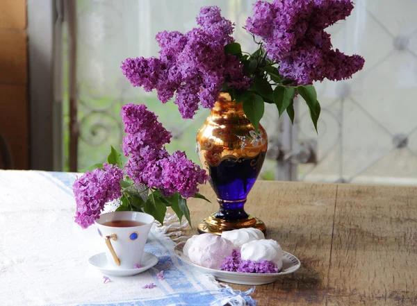 Bodegón con un zephyr, una taza de té y un ramo de lila — Foto de Stock