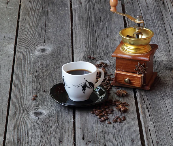 Coffee in a coffee cup in an environment of coffee grains and an — Stock Photo, Image