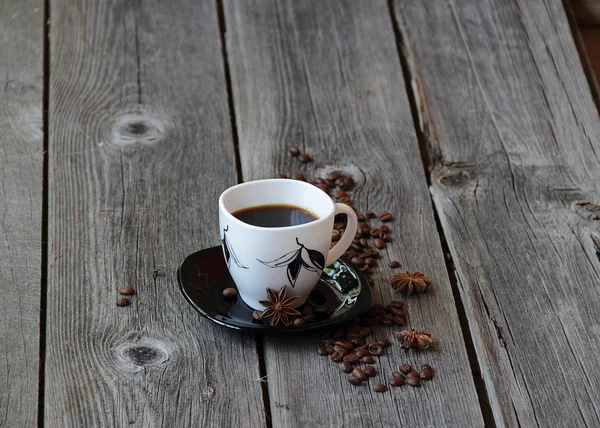 Café em uma xícara de café em um ambiente de grãos de café e um — Fotografia de Stock