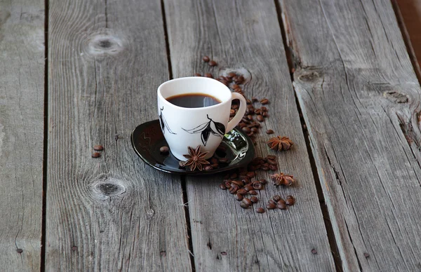 Café em uma xícara de café em um ambiente de grãos de café e um — Fotografia de Stock