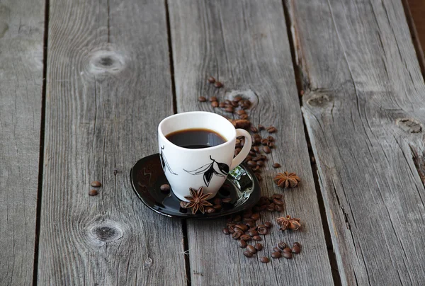 Café em uma xícara de café em um ambiente de grãos de café e um — Fotografia de Stock