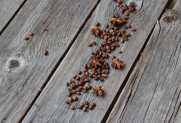 Grãos de café preto e um asterisco de anis em um backgro de madeira — Fotografia de Stock