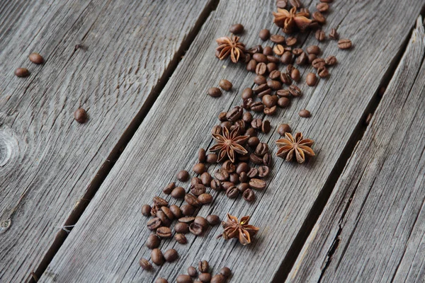 Grãos de café preto e um asterisco de anis em um backgro de madeira — Fotografia de Stock
