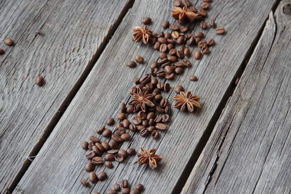 ブラック コーヒーと木製の backgro にアニス アスタリスクの粒 — ストック写真