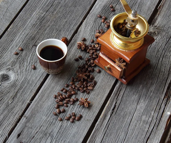 Cup of coffee and manual coffee grinder on a wooden background — Stock Photo, Image