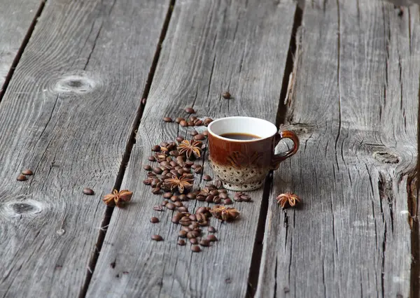 Copo de café em um ambiente de grãos de café em um b de madeira — Fotografia de Stock