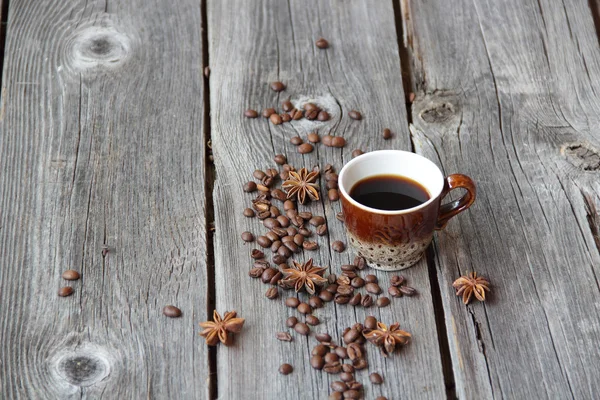Copo de café em um ambiente de grãos de café em um b de madeira — Fotografia de Stock