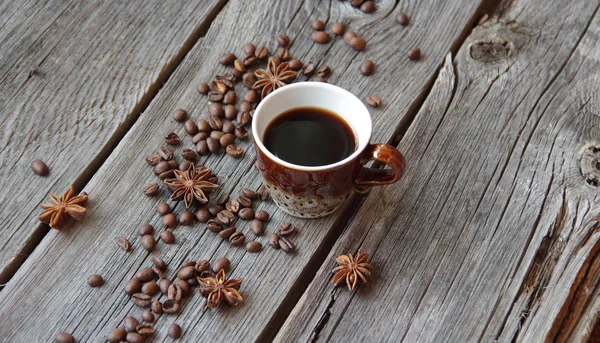Cup from coffee in an environment of coffee grains on a wooden b — Stock Photo, Image