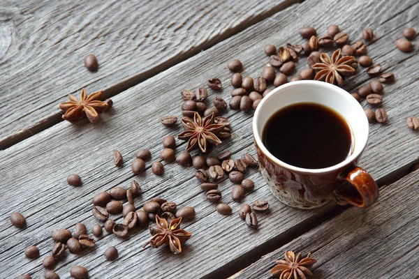 Taza de café en un ambiente de granos de café en una b de madera — Foto de Stock