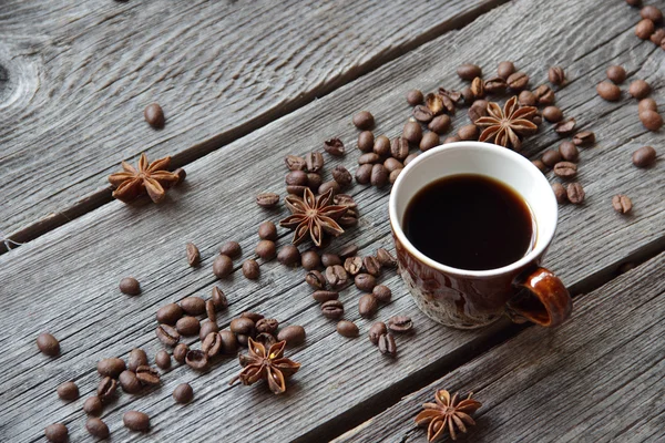 Taza de café en un ambiente de granos de café en una b de madera — Foto de Stock