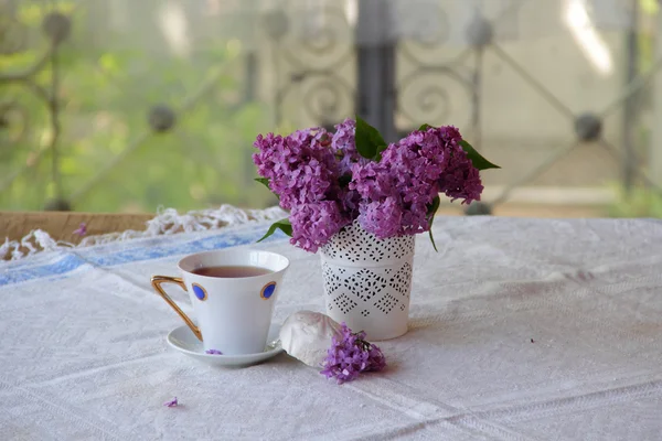 Bodegón con té, un zephyr y un ramo de lila — Foto de Stock
