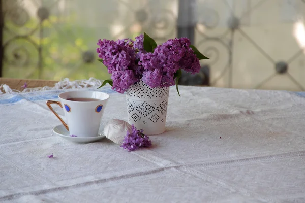 Bodegón con té, un zephyr y un ramo de lila — Foto de Stock