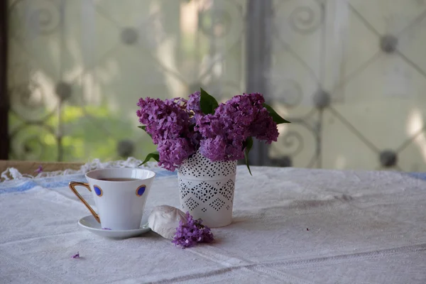 Bodegón con té, un zephyr y un ramo de lila — Foto de Stock