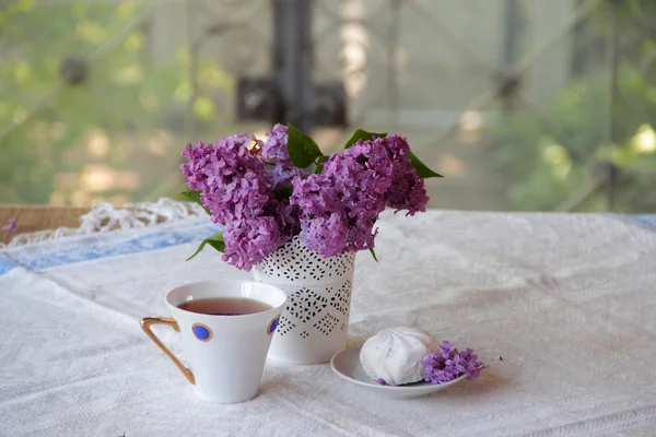 Té presentado con un zephyr, y una lila en un hermoso jarrón — Foto de Stock