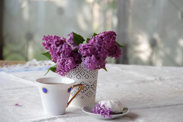 Té con un zephyr y un ramo de lila en un hermoso jarrón — Foto de Stock