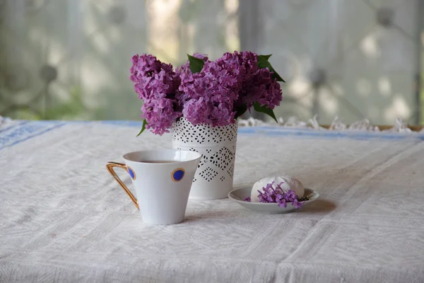Té con un zephyr y un ramo de lila en un hermoso jarrón — Foto de Stock
