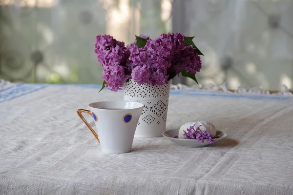 Té con un zephyr y un ramo de lila en un hermoso jarrón — Foto de Stock