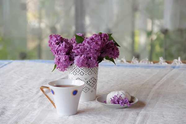 Té con un zephyr y un ramo de lila en un hermoso jarrón — Foto de Stock