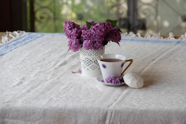 Tee mit einem Zephyr und einem Fliederstrauß in einer schönen Vase — Stockfoto