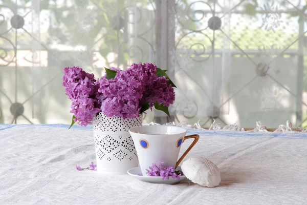 Té con un zephyr y un ramo de lila en un hermoso jarrón — Foto de Stock