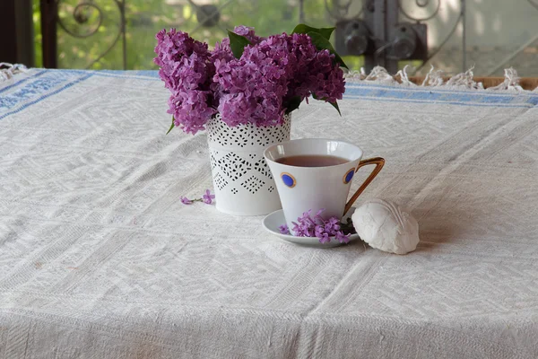 Té con un zephyr y un ramo de lila en un hermoso jarrón — Foto de Stock