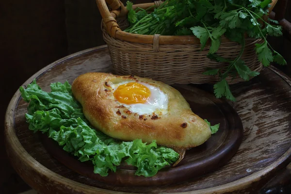 Torta aperta con un uovo presentato su foglie d'insalata verde — Foto Stock