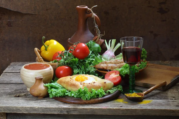 Still-life with a pie, fresh vegetables and red wine — Stock Photo, Image