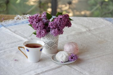 Bir leylak, Zephyr'i ve güzel bir fincan çay ile natürmort