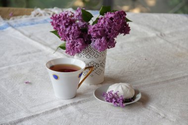 Bir leylak, Zephyr'i ve güzel bir fincan çay ile natürmort