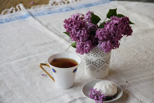 Натюрморт с сиренью, зефир и чай в красивой чашке — стоковое фото