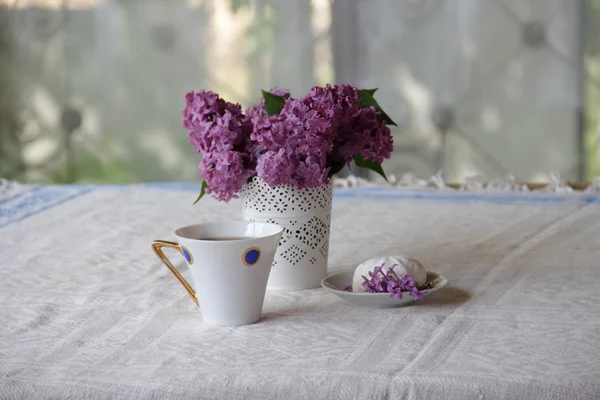 Bodegón con una lila, un zephyr y té en una hermosa taza — Foto de Stock