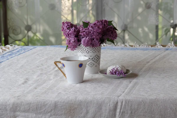 Bodegón con una taza de té, un zephyr y un ramo de lila — Foto de Stock