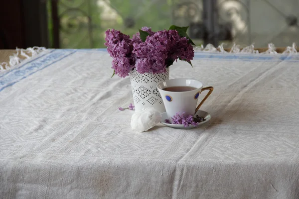 Натюрморт с чашкой чая, зефиром и лиловым букетом — стоковое фото