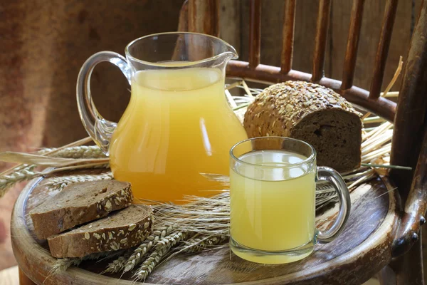 Kvas (Kvas) şeffaf bir kupa, bir sürahi ve çavdar ekmeği
