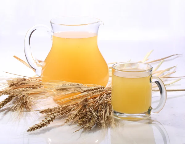 Bebida de grano - kvass (kvas) en una jarra transparente sobre un respaldo blanco —  Fotos de Stock